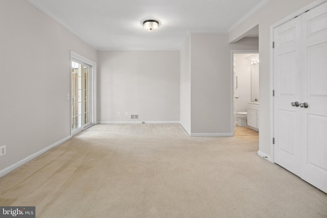 spare room with light carpet, visible vents, baseboards, and ornamental molding