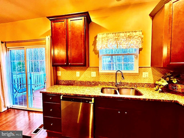 kitchen with dishwasher, plenty of natural light, light stone countertops, and a sink