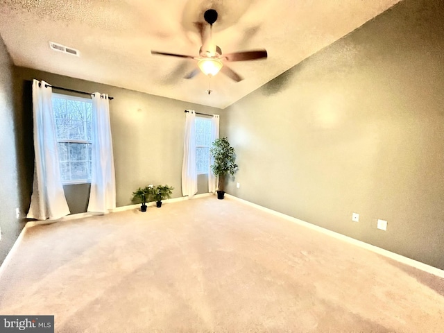 spare room with visible vents, carpet floors, baseboards, and ceiling fan