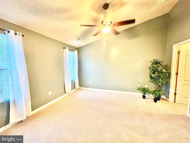 spare room featuring plenty of natural light, carpet, and vaulted ceiling