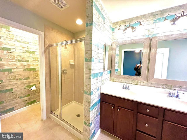 bathroom with vanity, visible vents, a stall shower, wood walls, and tile patterned floors