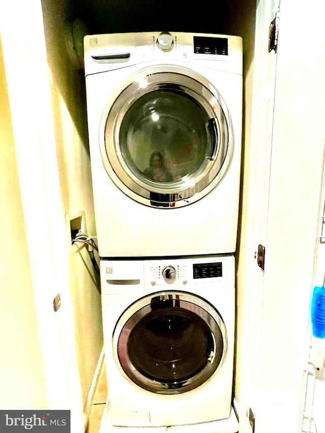 clothes washing area with stacked washer / drying machine and laundry area