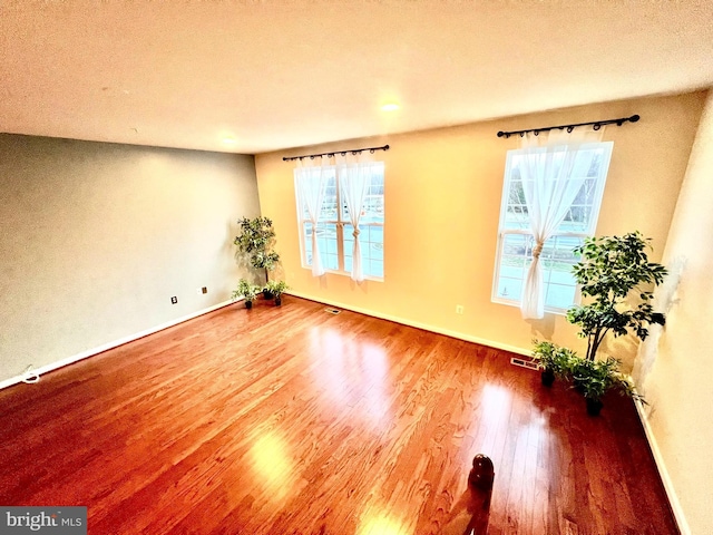 unfurnished room featuring baseboards, a textured ceiling, and wood finished floors