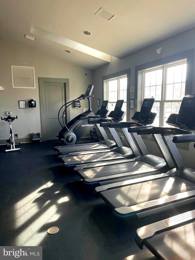 gym with visible vents and vaulted ceiling