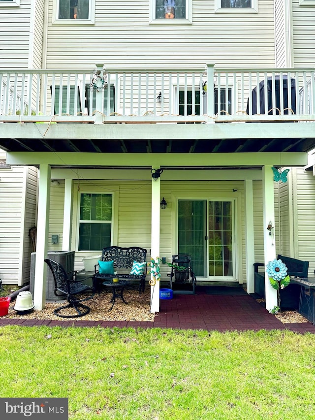 back of property with an outdoor living space and a patio area