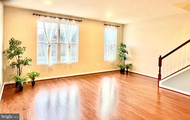 interior space featuring baseboards, wood finished floors, and stairs