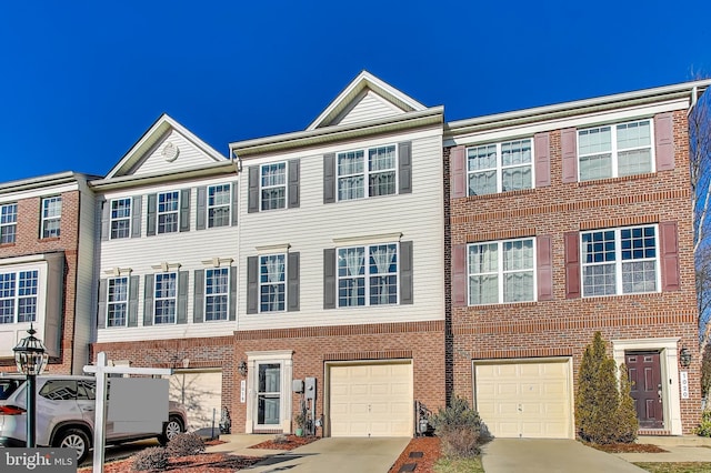 view of property featuring brick siding, an attached garage, and driveway