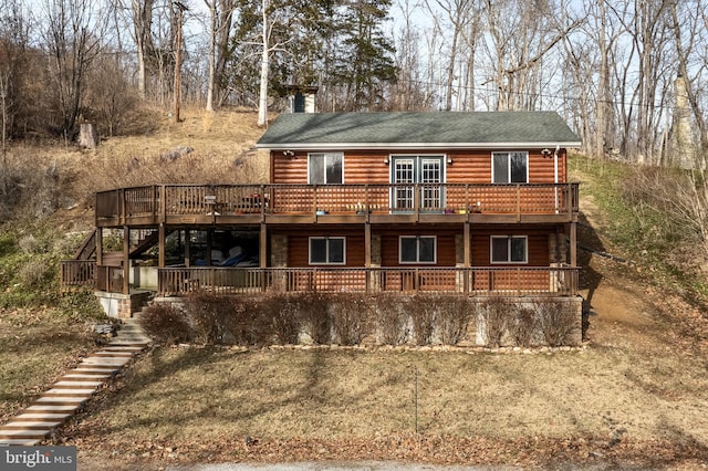 view of front of home featuring log veneer siding, stairs, a chimney, and a wooden deck