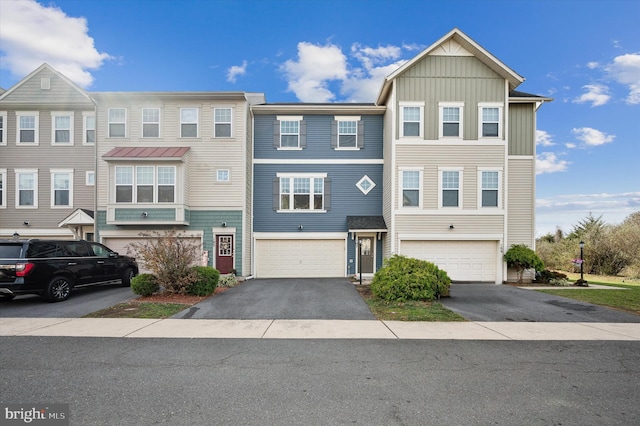 view of property featuring driveway, an attached garage, and board and batten siding