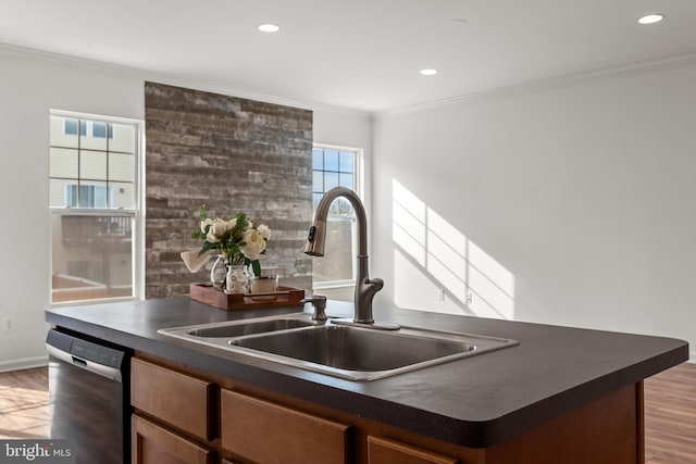 kitchen with a sink, dishwashing machine, dark countertops, and ornamental molding
