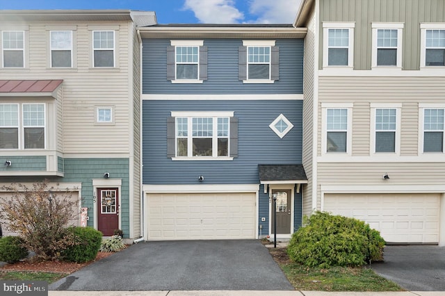 townhome / multi-family property with an attached garage and driveway