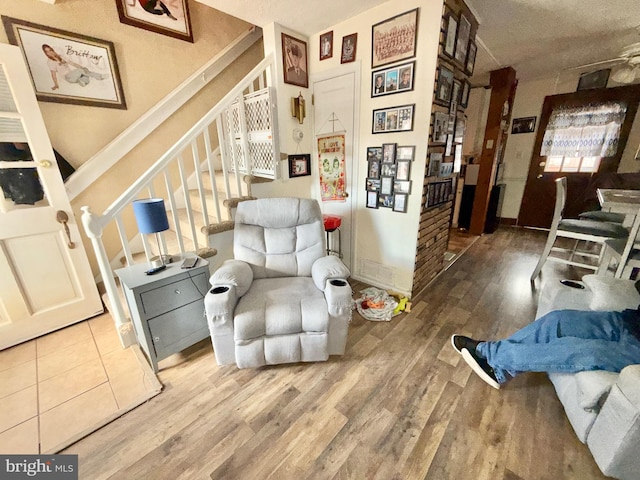 living area with stairway, wood finished floors, and baseboards