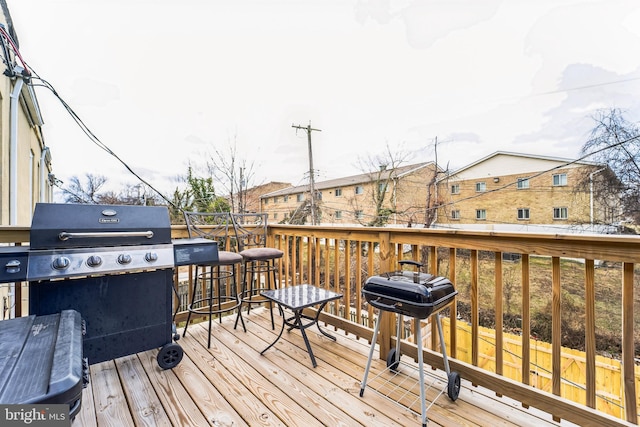 wooden deck featuring a residential view and a grill