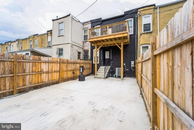 rear view of property with entry steps, a patio, and fence