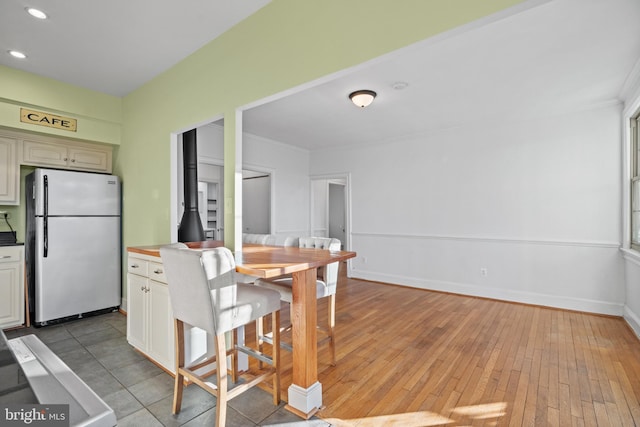 kitchen featuring light wood-style floors, freestanding refrigerator, baseboards, and recessed lighting