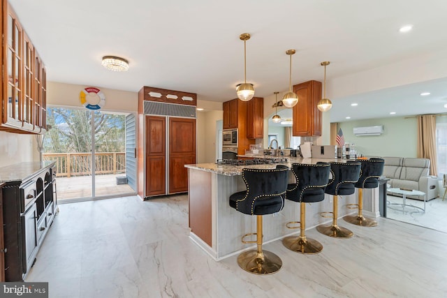 kitchen with light stone counters, a breakfast bar area, marble finish floor, an AC wall unit, and stainless steel microwave