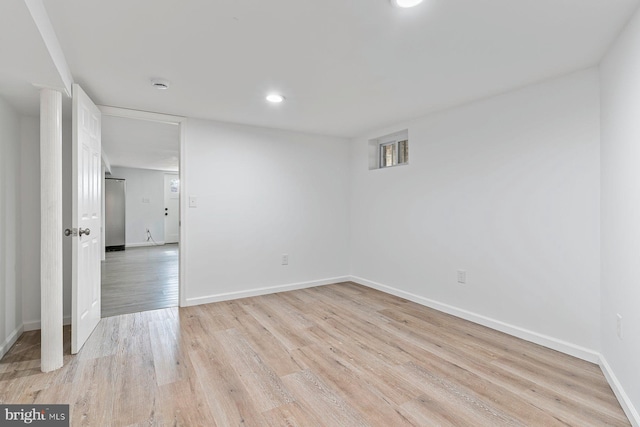 spare room featuring recessed lighting, light wood-type flooring, and baseboards