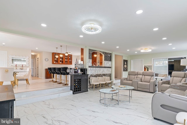 living area with marble finish floor, indoor bar, and recessed lighting