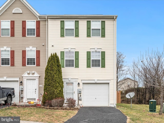 townhome / multi-family property featuring aphalt driveway and a garage