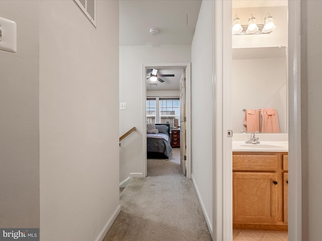 125 Monticello Sq, Winchester, VA 22602 - hall with visible vents, baseboards, light colored carpet, an upstairs landing, and a sink