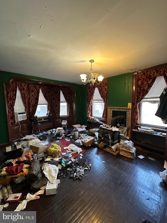 miscellaneous room featuring a notable chandelier, cooling unit, and wood-type flooring