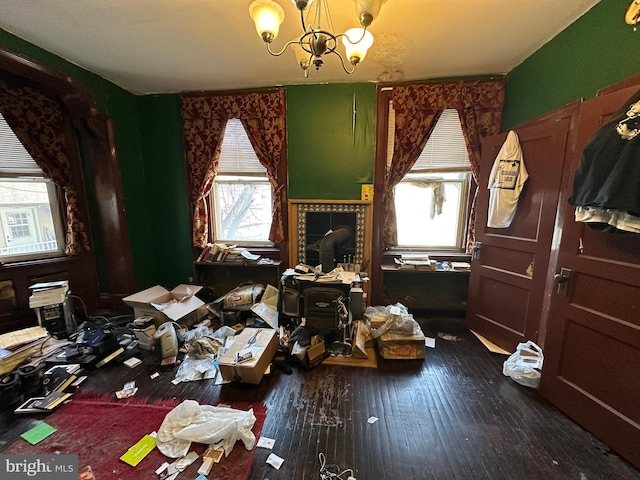 miscellaneous room featuring dark wood-style flooring and a chandelier