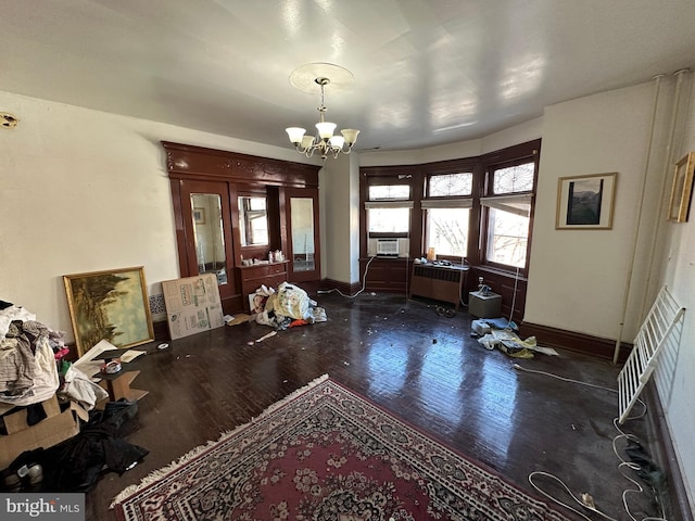 entrance foyer featuring radiator, wood finished floors, cooling unit, baseboards, and a notable chandelier