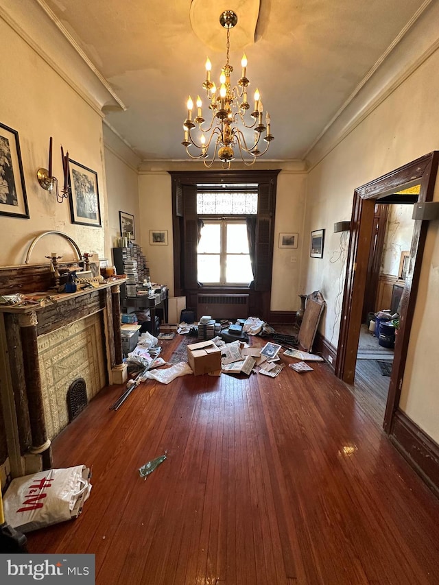 interior space featuring hardwood / wood-style floors, crown molding, baseboards, and an inviting chandelier