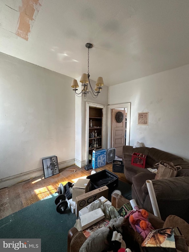 living room with baseboards, an inviting chandelier, and wood finished floors