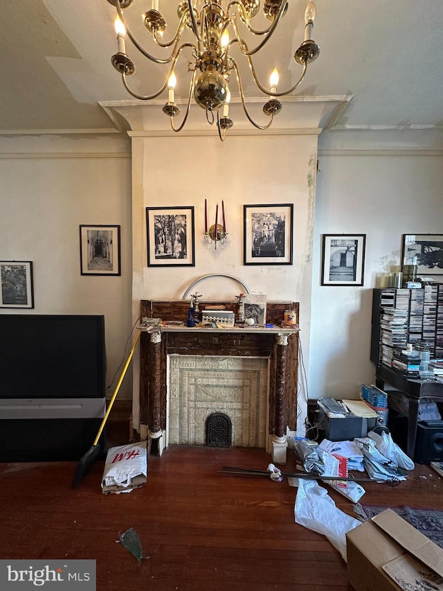 living area with crown molding, wood finished floors, and a chandelier