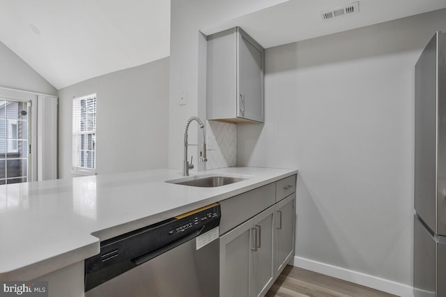 kitchen with a sink, visible vents, light countertops, and stainless steel dishwasher