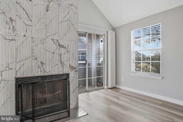 interior space with lofted ceiling, wood finished floors, and baseboards