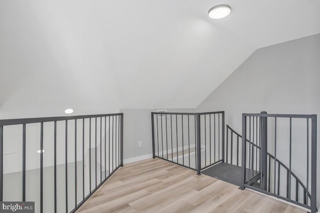 additional living space with lofted ceiling, wood finished floors, and baseboards