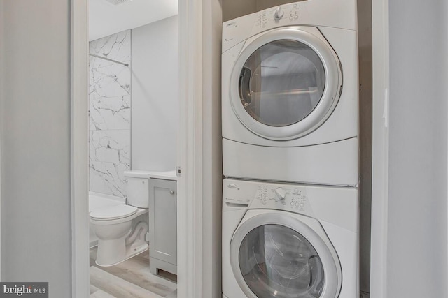 washroom with laundry area and stacked washer / drying machine