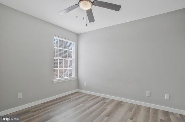 empty room featuring wood finished floors, a ceiling fan, and baseboards