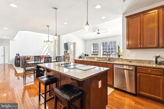 kitchen with a kitchen island, a sink, stainless steel dishwasher, black electric cooktop, and open floor plan