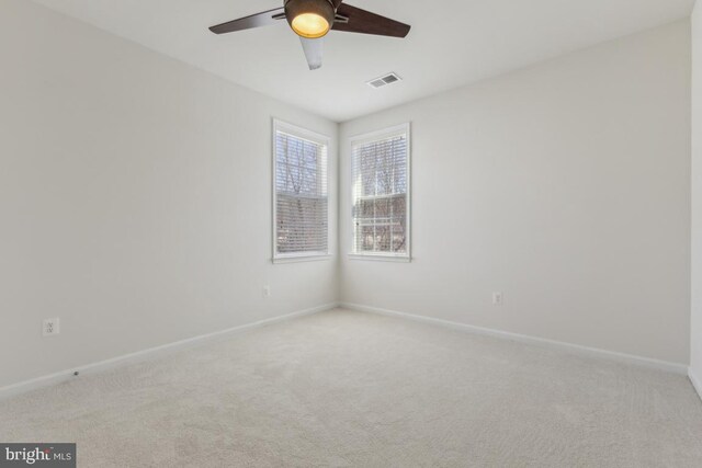 spare room featuring visible vents, baseboards, light colored carpet, and ceiling fan