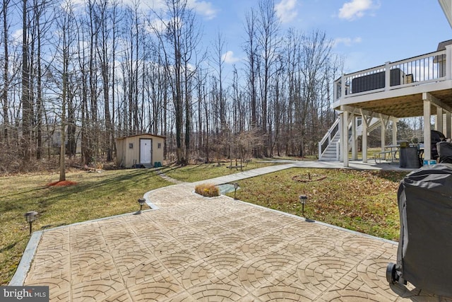 view of patio featuring an outbuilding, stairway, and a wooden deck