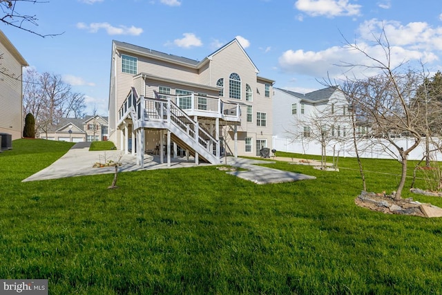 rear view of house featuring a yard, a deck, stairs, and a patio area