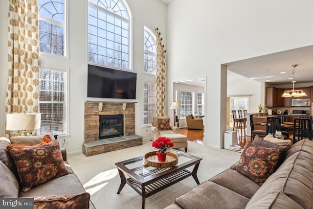 carpeted living area with baseboards, a healthy amount of sunlight, and a fireplace