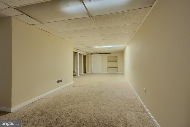 carpeted spare room featuring a drop ceiling, visible vents, and baseboards