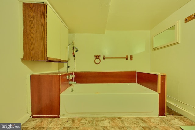 full bath featuring baseboards and a bath