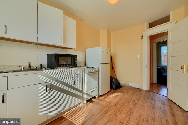 kitchen featuring tasteful backsplash, white appliances, white cabinets, and light wood-style floors