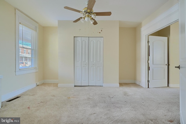 unfurnished bedroom with carpet floors, baseboards, visible vents, and a closet