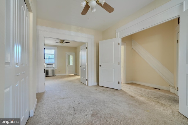 hall with radiator, carpet flooring, visible vents, and baseboards