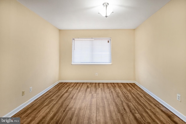 unfurnished room with wood finished floors and baseboards