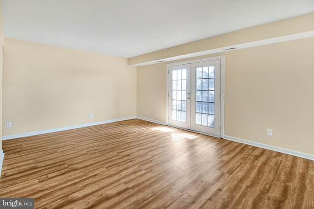 unfurnished room with french doors, visible vents, baseboards, and wood finished floors