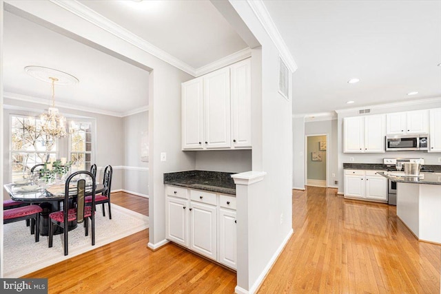 kitchen featuring light wood-type flooring, appliances with stainless steel finishes, crown molding, and white cabinetry