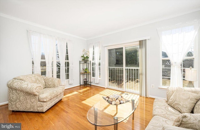 living area with ornamental molding, baseboards, and wood finished floors