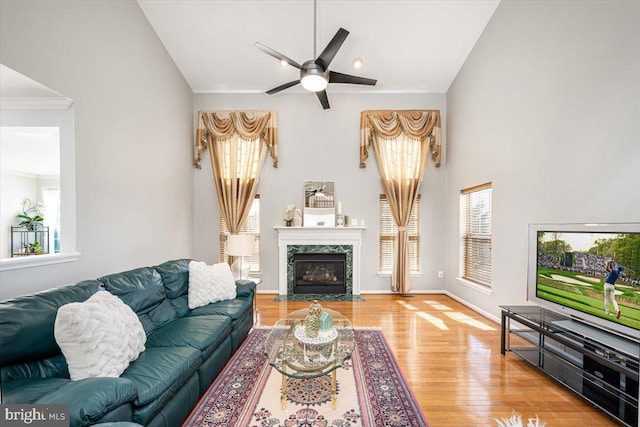 living area featuring a high end fireplace, vaulted ceiling, wood finished floors, and a wealth of natural light